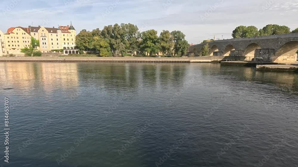 Old Stone Bridge spans the Danube River on a sunny day in Regensburg city in Bavaria, Germany