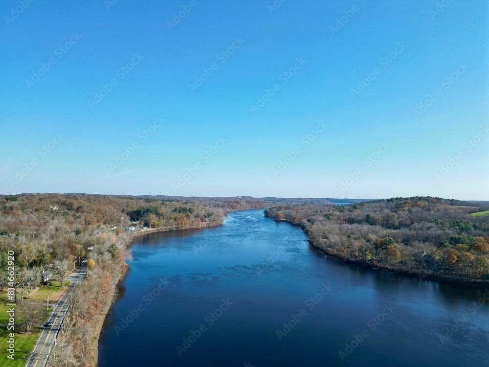 Tranquil scene of a tranquil river flanked by lush greenery, with trees on either side of the banks Tranquil scene of a tranquil river flanked by lush greenery, with trees on either side of the banks