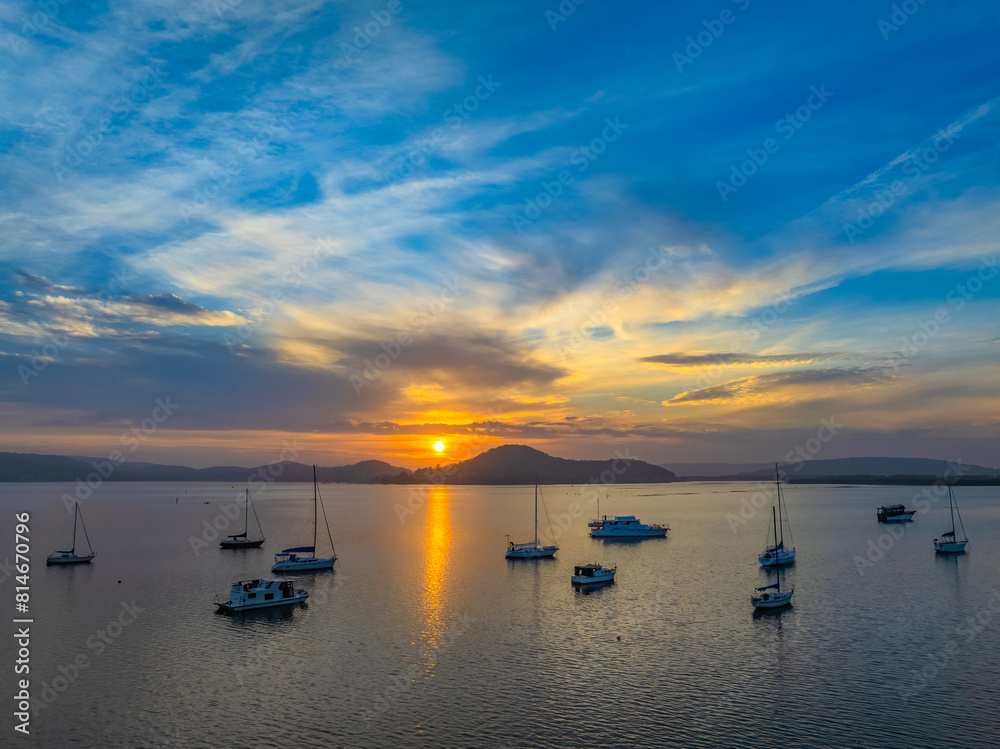 Hazy aerial sunrise waterscape in soft pastel colours with boats and high cloud Hazy aerial sunrise waterscape in soft pastel colours with boats and high cloud