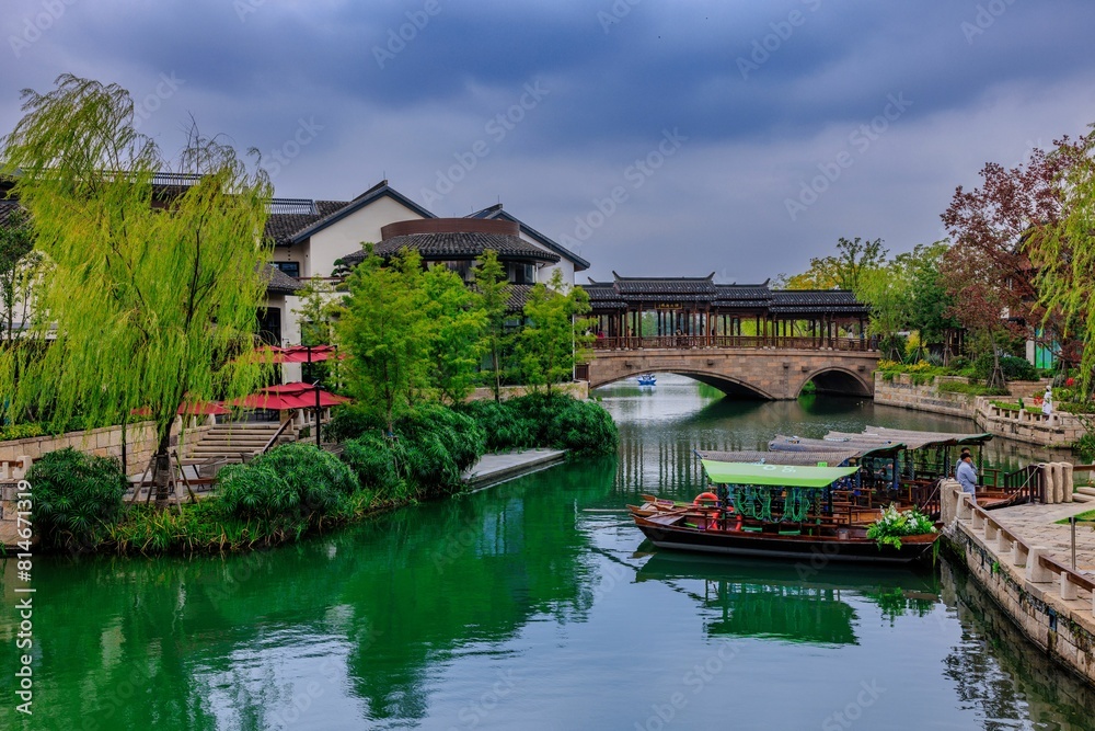 Picturesque arched bridge spanning a tranquil body of water on a cloudy day in Shanghai, China Picturesque arched bridge spanning a tranquil body of water on a cloudy day in Shanghai, China