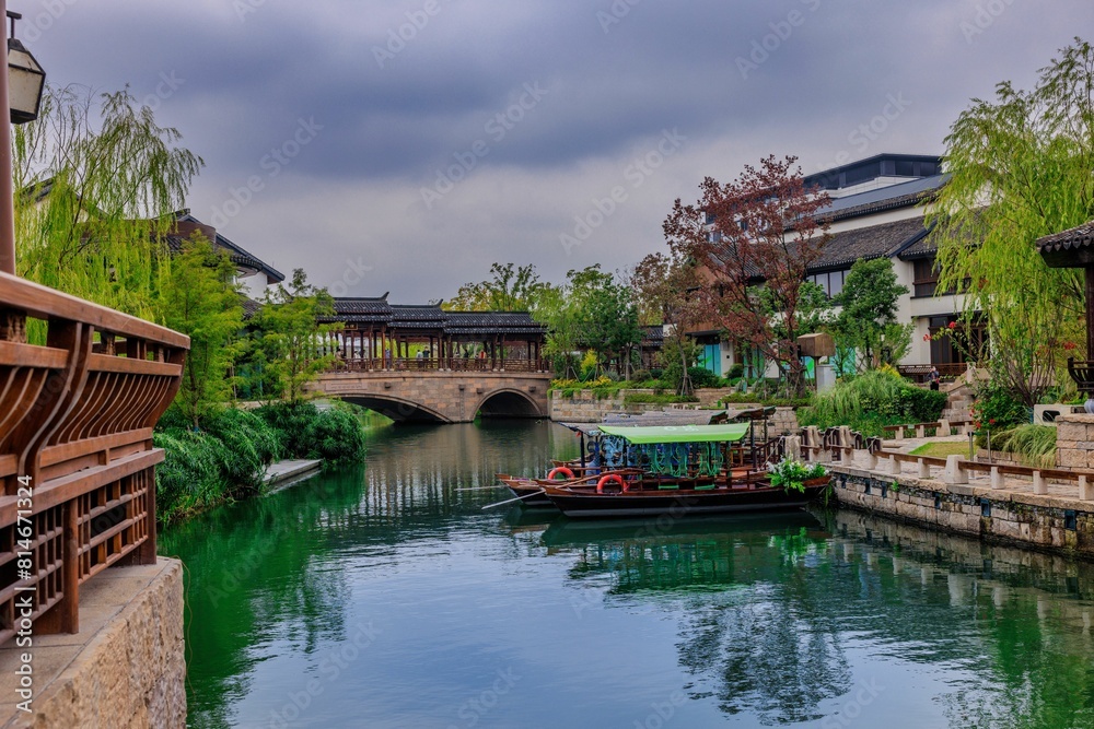 Picturesque arched bridge spanning a tranquil body of water on a cloudy day in Shanghai, China Picturesque arched bridge spanning a tranquil body of water on a cloudy day in Shanghai, China