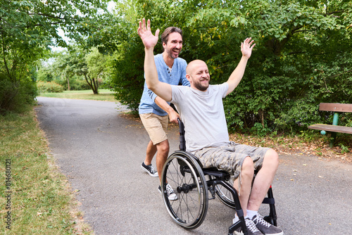 Man in wheelchair and friend enjoying a day at the park, sharing laughter and joy