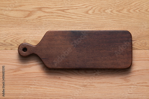 Wooden cutting board. Handmade wooden cutting board on oak tabletop.