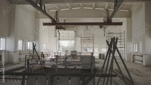 Gantry crane and scaffolds in restored factory storehouse. Hoist for freights carrying and building supplies in industrial workshop photo