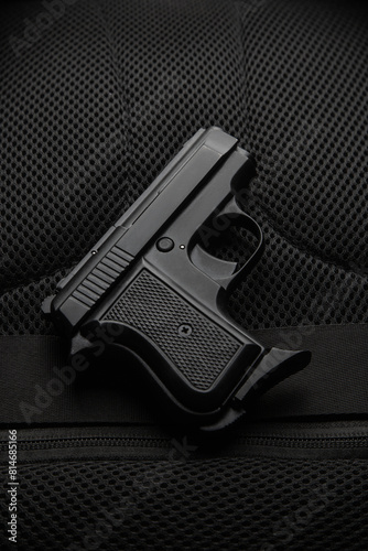 A small semi-automatic pistol on a dark background. Weapons for concealed carry and self-defense. Short-barreled weapon. photo