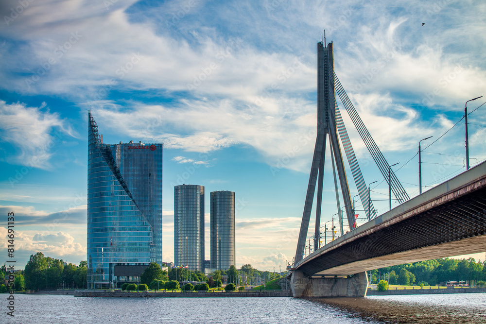 Fototapeta premium Riga, Latvia - July 7, 2017: Riga bridge and modern buildings on a sunny afternoon