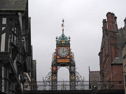 The Eastgate clock and clock in Chester city walls surrounded by the historic buildings on the road