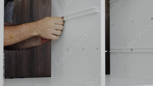 Installation of a drawer on guides in a cabinet. Furniture assembler by handyman.