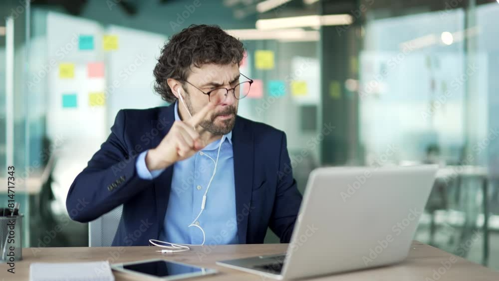 Angry dissatisfied businessman in a formal suit arguing on a video call using a laptop sitting at workplace in business office. Excited man boss emotionally talks with a subordinate about problems Angry dissatisfied businessman in a formal suit arguing on a video call using a laptop sitting at workplace in business office. Excited man boss emotionally talks with a subordinate about problems