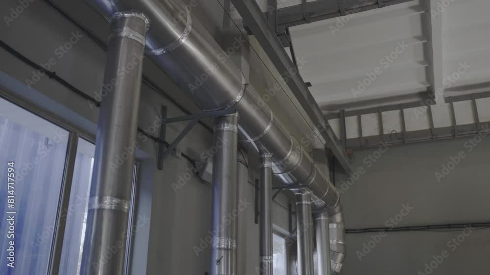 Steel gas distribution piles near window in plant workshop. System of chemicals processing installed in factory shop. Industrial facility Steel gas distribution piles near window in plant workshop. System of chemicals processing installed in factory shop. Industrial facility