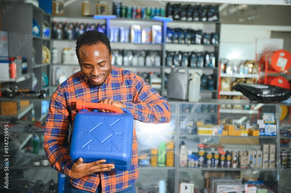 seller man with canister of motor oil in auto store seller man with canister of motor oil in auto store