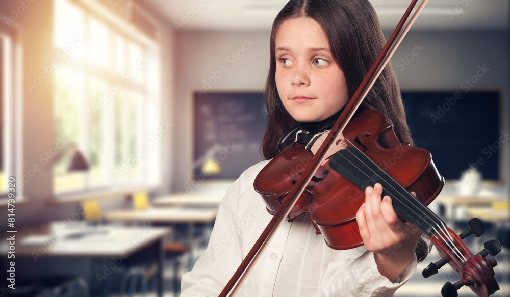 Schoolgirl learning to play in music class Schoolgirl learning to play in music class