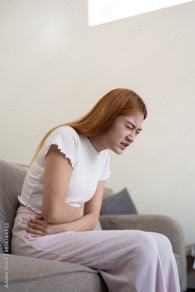 Asian woman having painful from stomach ache at home, Female suffering with abdominal pain Asian woman having painful from stomach ache at home, Female suffering with abdominal pain