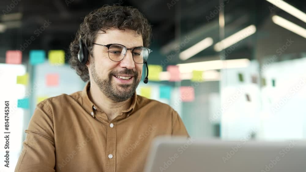 Businessman headset talking on a video call using a laptop sitting in office. Coach has a business meeting. speaks remotely at an online training. Call center agent helping customer with complaints Businessman headset talking on a video call using a laptop sitting in office. Coach has a business meeting. speaks remotely at an online training. Call center agent helping customer with complaints