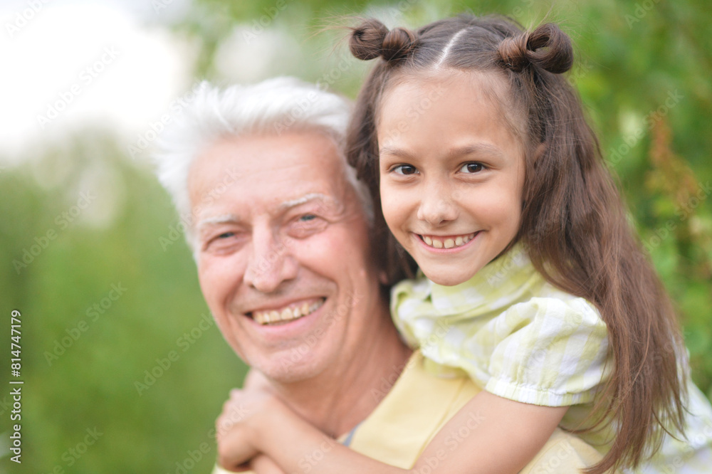 Portrait of happy grandfather and granddaughter having fun in park Portrait of happy grandfather and granddaughter having fun in park