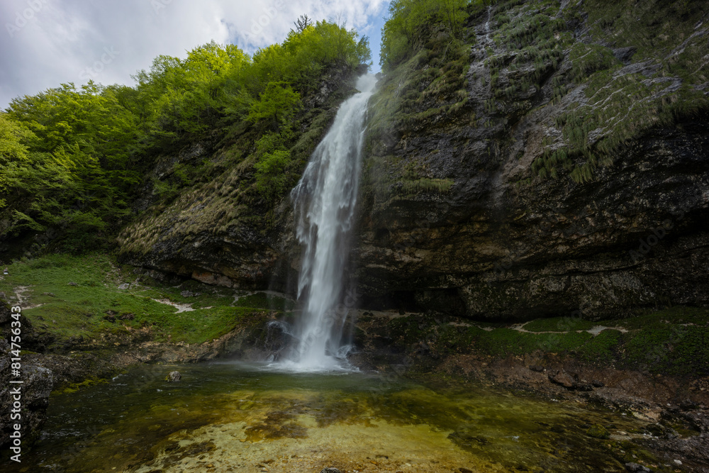 Fontanon of Goriuda, Udine. Wonderful waterfall that falls from a cliff. The force of the waterfall is a sight to behold. Hiking, trekking in the open area surrounded by woods. Summer holidays, peace. Fontanon of Goriuda, Udine. Wonderful waterfall that falls from a cliff. The force of the waterfall is a sight to behold. Hiking, trekking in the open area surrounded by woods. Summer holidays, peace.