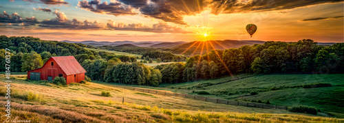 The sun is setting over lush green valley with fence in the foreground.