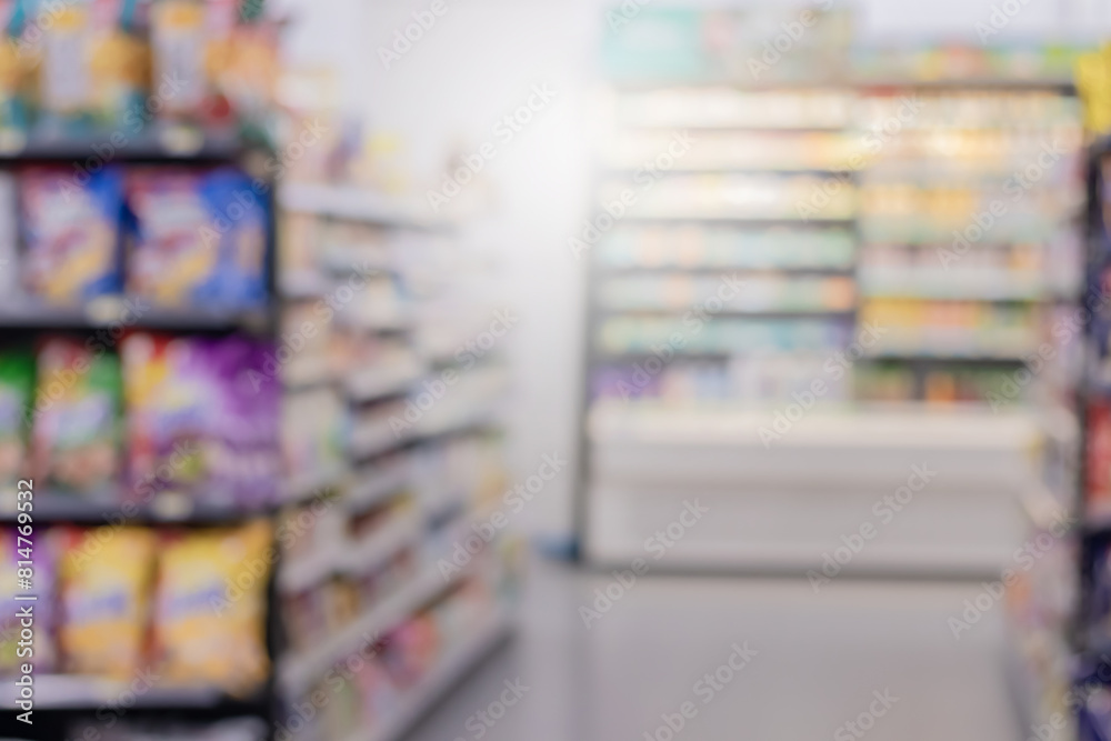 Obraz premium Abstract blurred supermarket aisle with colorful shelves and unrecognizable customers as background