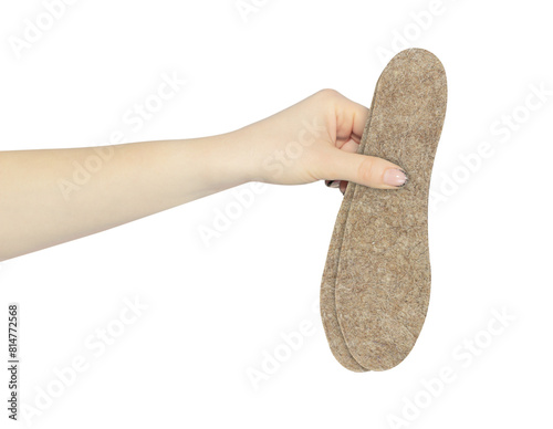 felt insoles for shoes in hand, outstretched hand with shoe insoles isolated from background photo