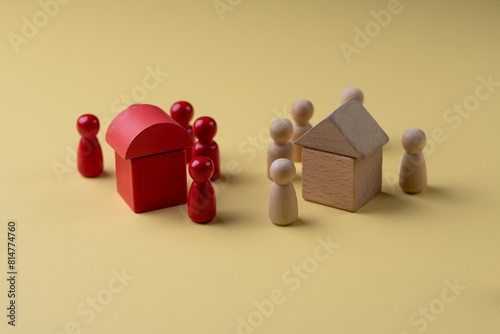 Wood House Model and wooden figurines on yellow background ,Property, hospitality concept using wooden house and human model.
