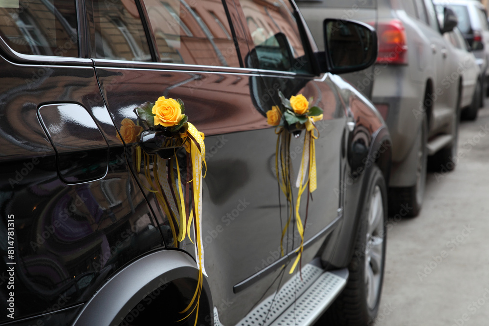 The car is decorated with gold ribbons and roses for the occasion.