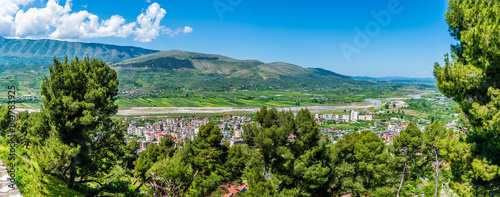 A panorama view past trees from the castle overlooking the northern side of Berat  Albania in summertime 