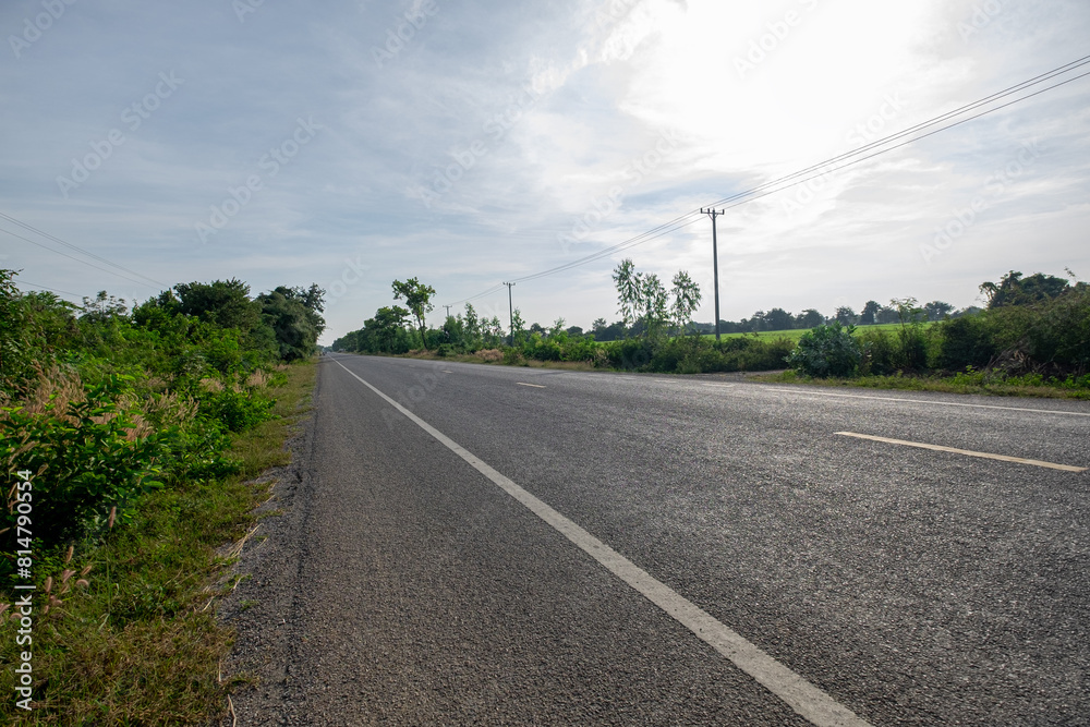 An Empty Asphalt Road in a Remote Rural Area, Surrounded by Simple, Peaceful, and Beautiful Nature An Empty Asphalt Road in a Remote Rural Area, Surrounded by Simple, Peaceful, and Beautiful Nature