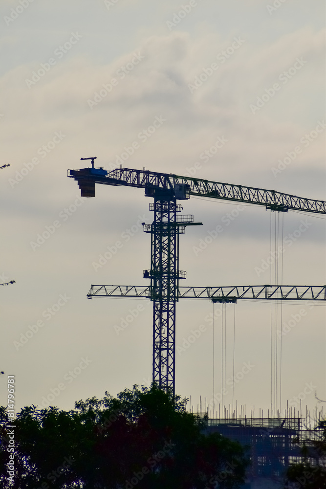 Close-up of construction crane with clear sky in background. Construction scene and city development. Close-up of construction crane with clear sky in background. Construction scene and city development.