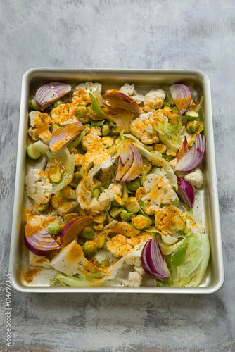 Cauliflower florets with red onions and turmeric in a roasting tin photo