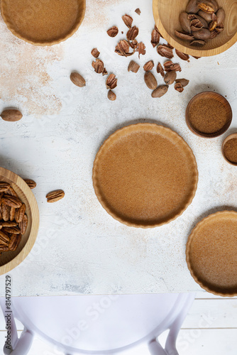 Baked pie crusts on a table with pecans photo