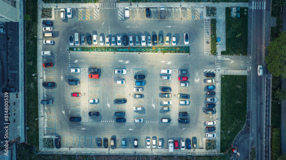 Top view of car park at night. Cars in the parking lot under the light of street lights Top view of car park at night. Cars in the parking lot under the light of street lights
