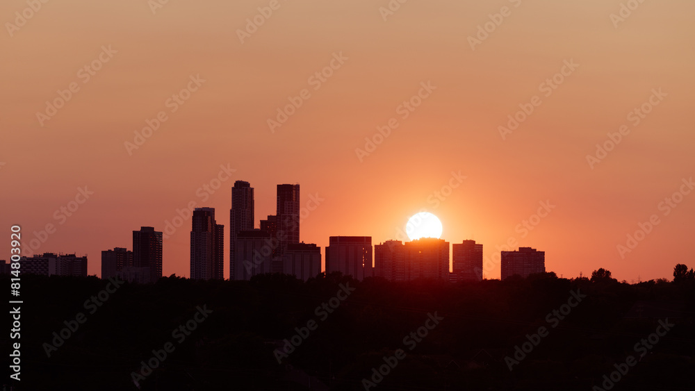 Sunset silhouette over urban cityscape at dusk
