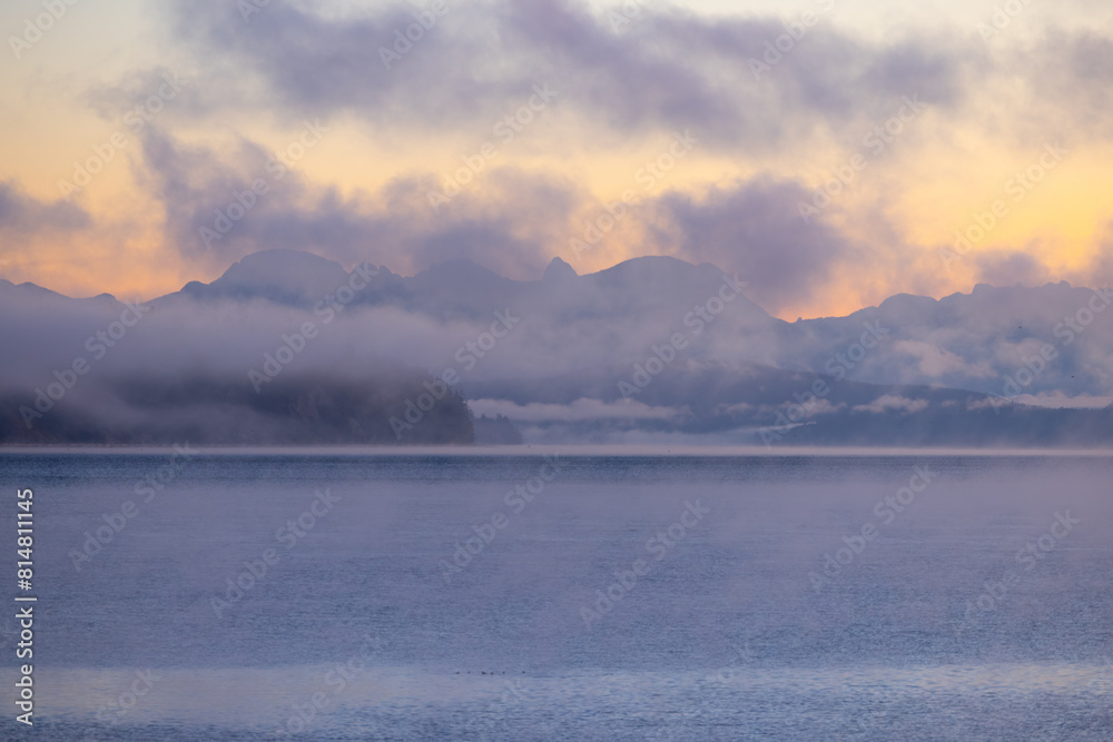 Sunset over British Columbia mountains at sea