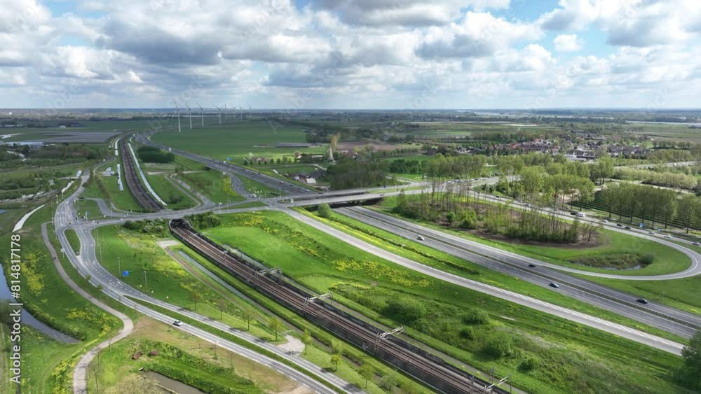 Drone of the vehicles driving on a highway under bridge and railway track in the view on a sunny day Drone of the vehicles driving on a highway under bridge and railway track in the view on a sunny day