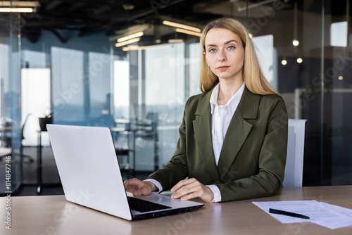 Confident businesswoman working on laptop at modern office desk