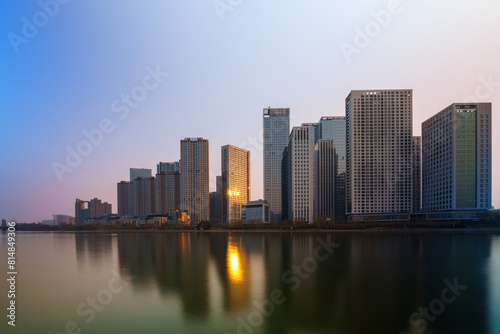 Skyscrapers reflection upon a river at sunset in Tongzhou District, Beijing, China, which is a newly-established business district