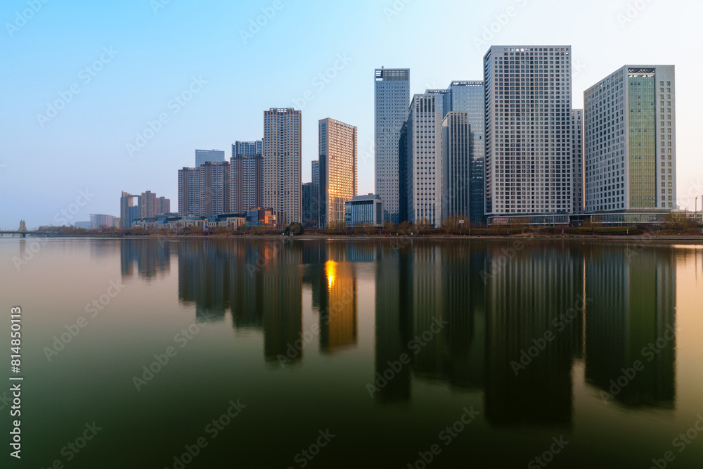 Skyscrapers reflection upon a river at sunset in Tongzhou District, Beijing, China, which is a newly-established business district Skyscrapers reflection upon a river at sunset in Tongzhou District, Beijing, China, which is a newly-established business district