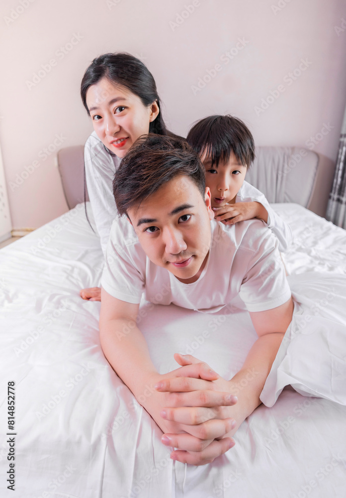 A family of three in the bed in the bedroom A family of three in the bed in the bedroom
