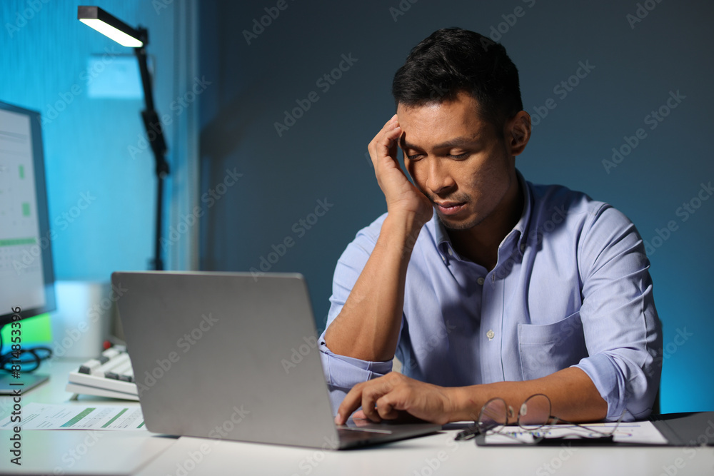 Serious businessman is stressed and busy working overtime in the office. Serious businessman is stressed and busy working overtime in the office.