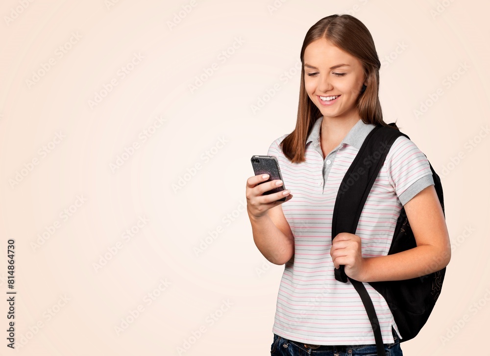 Cheerful teen student smiling using smartphone Cheerful teen student smiling using smartphone