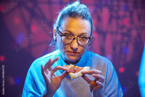 Dissatisfied woman judge with glasses tastes pizza