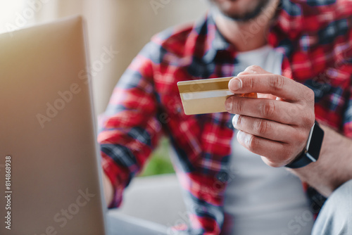 Cropped shot of man holding credit card near laptop  online paying shopping  e-commerce  internet banking  spending money  work from home concept. Modern technology and people concept
