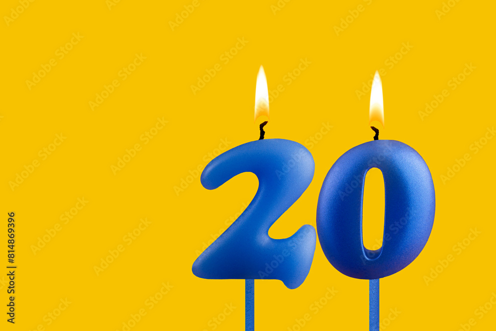 Blue birthday candle on yellow background - Number 20 Blue birthday candle on yellow background - Number 20