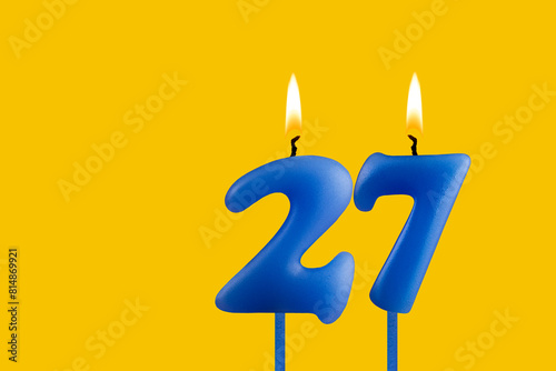 Blue candle number 27 - Birthday on yellow background