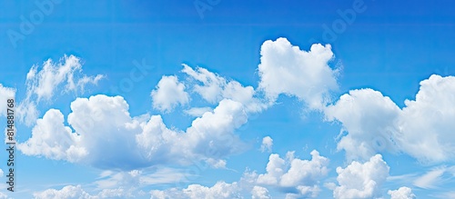 A clear blue sky with small clouds creating a picturesque copy space image