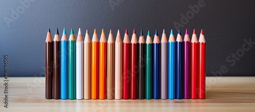 A copy space image of colored pencils arranged on a wooden table for a presentation