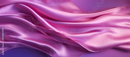 There is a copy space image of a crumpled pink satin fabric banner on a shiny purple background