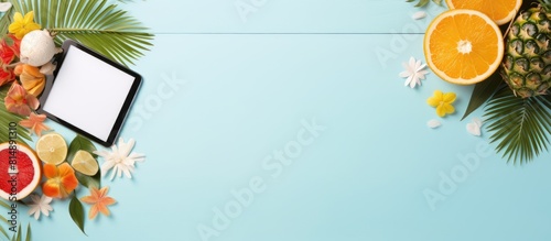 Fototapeta Naklejka Na Ścianę i Meble -  Top view copy space image of a vibrant summer holiday background It showcases a tablet with an empty screen adorned with a tropical cocktail summer fruits and palm leaves The tablet rests on a serene