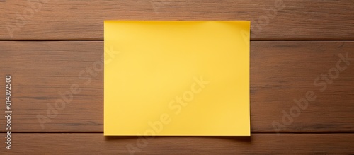 A post it note and pencil on a wooden table captured from above with ample copy space available