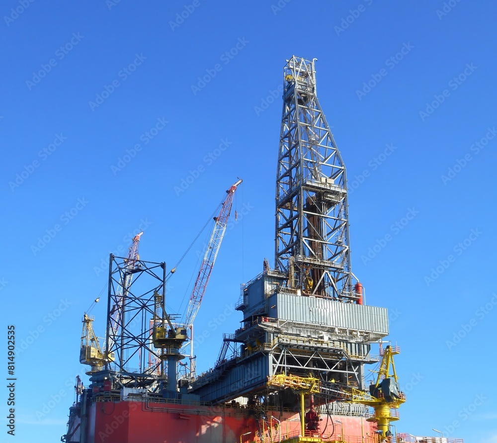 Offshore drilling rig showing derrick, drill floor, cranes, drill pipe with clear blue sky background. High resolution image Offshore drilling rig showing derrick, drill floor, cranes, drill pipe with clear blue sky background. High resolution image